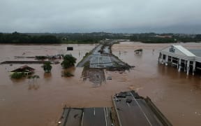 Grab from a handout video released by the Sao Paulo Civil Defense showing the flooded Taquari river bridge, which is part of the BR-396 highway that connects the cities of Lageado and Estrela, in the region of Vale do Taquari, Rio Grande do Sul state, Brazil on May 3, 2024.