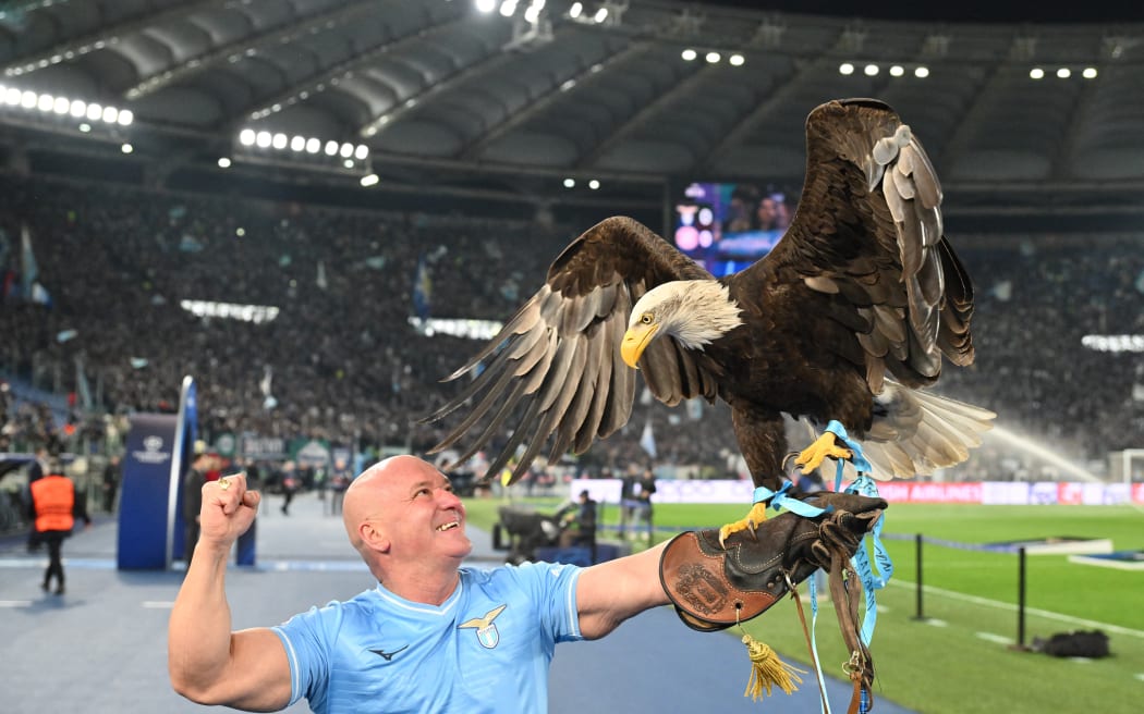 Falconer Jose Maria Bernabe holds Lazio's eagle mascot prior to a match in 2024.