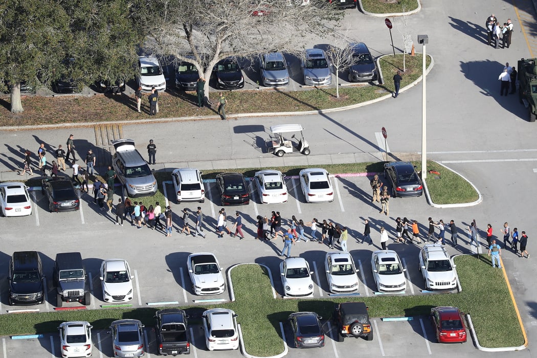 People are brought out of Marjory Stoneman Douglas High School after the shooting at the school that reportedly killed and injured multiple people.