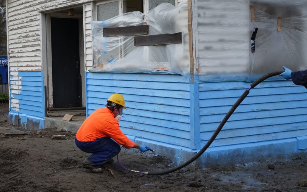 A water-proof membrane designed to protect flood-prone houses is sprayed on.