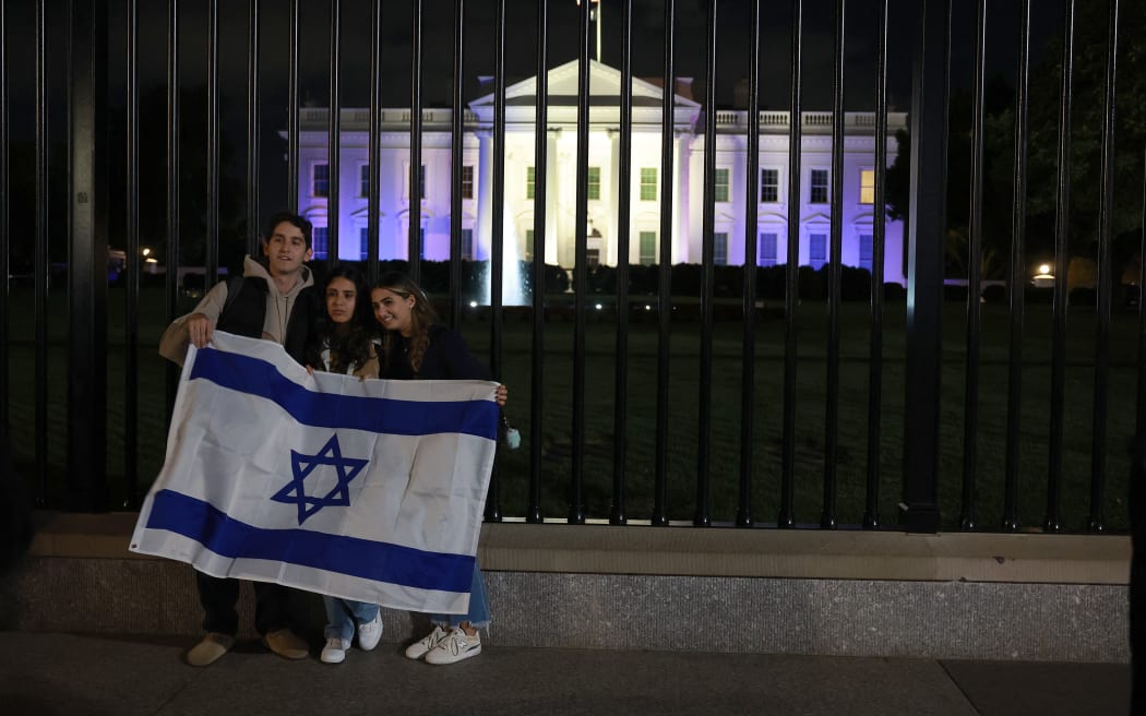 WASHINGTON, DC - OCTOBER 09: (L-R) Aviv, Talia, and Brielle, who declined to provide their last names, pose at the White House, which is illuminated in white and blue in support of Israel, on October 9, 2023 in Washington, DC. The show of support comes amid the weekend attacks on Israel by the Palestinian militant group Hamas that has claimed hundreds of lives and wounded thousands more.   Joe Raedle/Getty Images/AFP (Photo by JOE RAEDLE / GETTY IMAGES NORTH AMERICA / Getty Images via AFP)