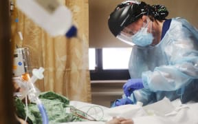 APPLE VALLEY, CALIFORNIA - DECEMBER 23: (EDITORIAL USE ONLY) Registered nurse Katelyn Musslewhite cares for a COVID-19 patient in the Intensive Care Unit (ICU) at Providence St. Mary Medical Center amid a surge in COVID-19 patients in Southern California on December 23, 2020 in Apple Valley, California. The 213 bed capacity hospital in San Bernardino County is currently treating at least 140 COVID 19-positive inpatients while operating at approximately 250 percent of ICU capacity. Southern California remains at zero percent of its ICU (Intensive Care Unit) bed capacity amid the spike in coronavirus cases and hospitalizations.   Mario Tama/Getty Images/AFP (Photo by MARIO TAMA / GETTY IMAGES NORTH AMERICA / Getty Images via AFP)