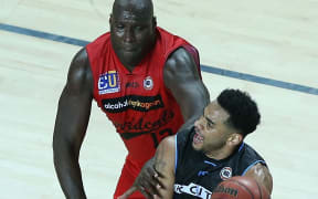 Perth player Nate Jawai defends Breakers guard Corey Webster