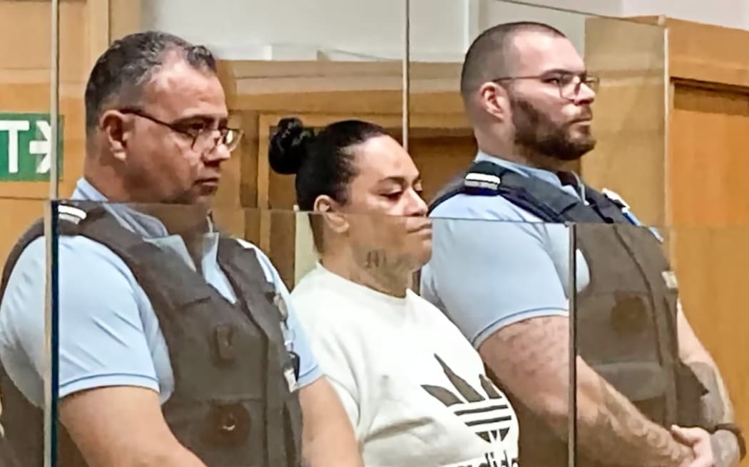 Ephron Ronaki appears in court, flanked by court security officers.