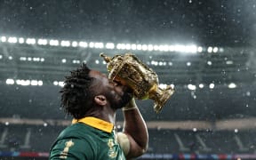 South Africa's flanker and captain Siya Kolisi kisses the Webb Ellis Cup as he celebrates winning the France 2023 Rugby World Cup final match against New Zealand at the Stade de France in Saint-Denis, on the outskirts of Paris, on October 28, 2023. (Photo by FRANCK FIFE / AFP)
