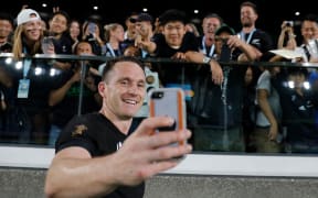 All Blacks full back Ben Smith takes a selfie with fans after winning the Japan 2019 Rugby World Cup Pool B match between New Zealand and South Africa.