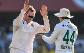 South Africa's Simon Harmer (L) celebrates with teammate Ryan Rickelton.