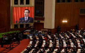 Chinese Premier Li Keqiang is shown on a screen as he delivers his work report during the opening session of the National People's Congress.