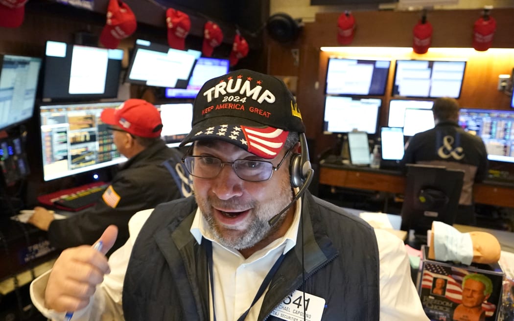 Trader Michael Capolino wears a Trump hat as he works on the floor of the New York Stock Exchange (NYSE) ahead of the opening bell on November 6, 2024, in New York City. - Wall Street stocks surged in opening trading on Wall Street Wednesday after US voters sent Donald Trump back to the White House and delivered him a Republican Senate. Major indices were up 1.8 percent or more in the early going as hopes about expected tax cuts and regulatory easing more than offset worries about higher tariffs. (Photo by TIMOTHY A. CLARY / AFP)