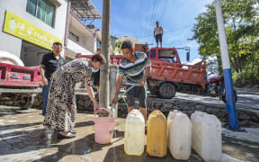 A villager gets water at a water distribution point in Luoping Village of Wushan County, southwest China's Chongqing, 13 August, 2022.