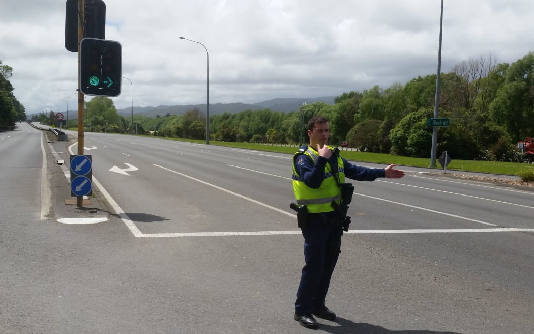 A policeman directing traffic at the road block at Melling in the Lower Hutt.