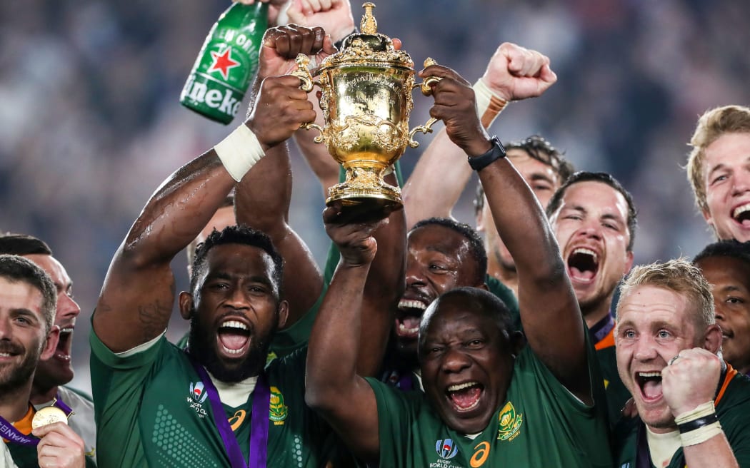 South Africa's Siya Kolisi lifts the Webb Ellis Trophy with Cyril Ramaphosa.