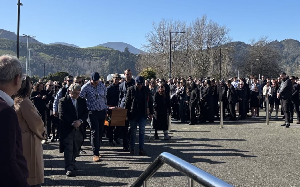Shane Christie's coffin is carried into the funeral service.