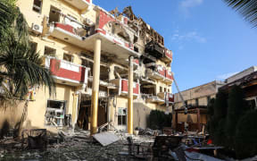 The damaged structure of the Hayat Hotel in Mogadishu is seen on August 21, 2022. - The death toll from a devastating 30-hour siege by Al-Shabaab jihadists at a hotel in Somalia's capital Mogadishu has climbed to 21, Health Minister Ali Haji Adan said Sunday.