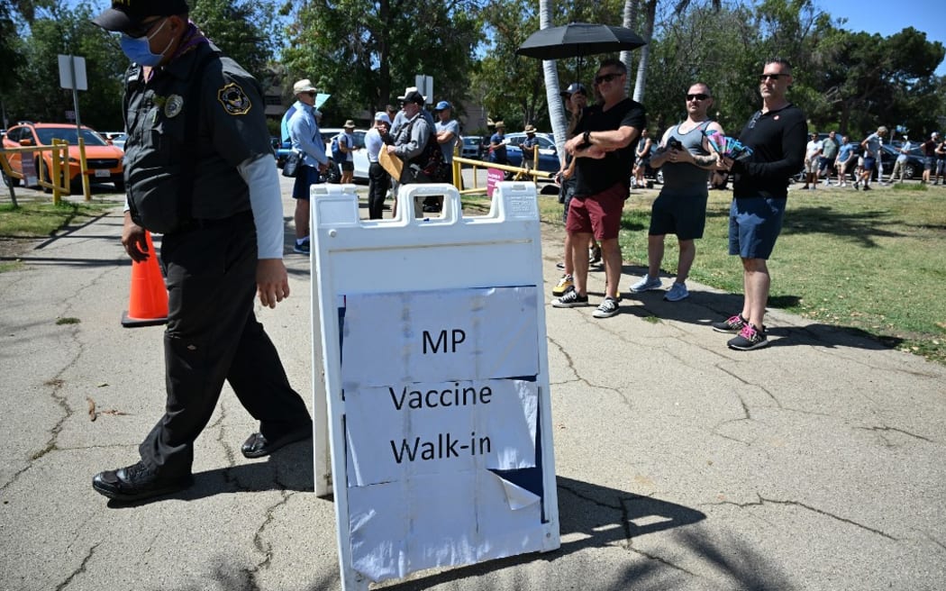 People wait in line to receive the monkeypox vaccine at the Balboa Sports Center in the Encino neighborhood of Los Angeles, California, on July 27, 2022. - In the face of limited supplies of vaccine and growing public concern, county officials have agreed to lobby federal health officials to bolster local supplies of monkeypox vaccines and boost funding for testing and administration of the shots.   As of July 26 there were 218 recorded cases of monkeypox in Los Angeles County. (Photo by Robyn Beck / AFP)