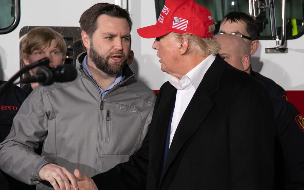 US Senator JD Vance (R-OH) (L) shakes hands with former US President Donald Trump during an event at the East Palestine Fire Department in East Palestine, Ohio, on February 22, 2023. Hundreds of evacuated residents have been allowed to return home following a cargo train derailment in East Palestine, Ohio, on February 3, 2023, however many have voiced alarm over health issues, with some reporting headaches and stating that they fear they may end up with cancer in several years. (Photo by Rebecca DROKE / AFP)