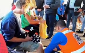 An image grab taken from a video made available by Egypt's Red sea governor’s office on November 25, 2024 shows rescue workers helping tourists and crew members after a diving boat capsized in the Red Sea off Egypt's coast. - Rescuers recovered four bodies and three survivors on November 26, a day after a a boat capsized off of Egypt's eastern coast, according to Red Sea governor Amr Hanafi, with nine people still missing. (Photo by Red Sea governor’s office / AFP) / RESTRICTED TO EDITORIAL USE - MANDATORY CREDIT "AFP PHOTO / RED SEA GOVERNOR'S OFFICE " - NO MARKETING NO ADVERTISING CAMPAIGNS - DISTRIBUTED AS A SERVICE TO CLIENTS