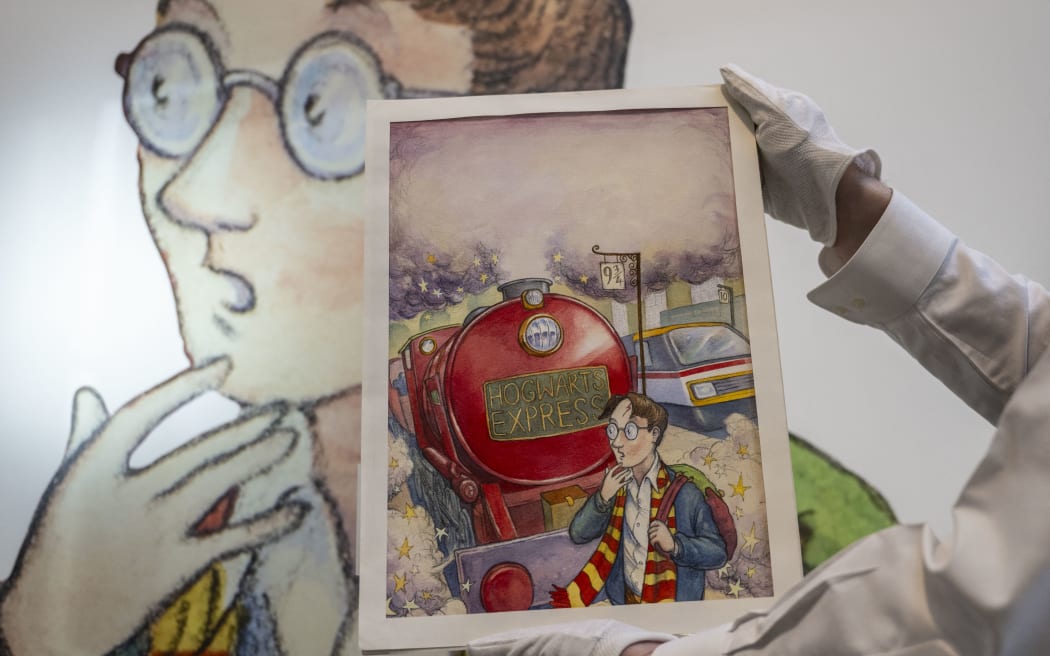 An art handler holds Thomas Taylor’s original cover art for J.K. Rowling's Harry Potter and the Philosopher’s Stone at Sotheby’s in New York on June 25, 2024. The item is the most valuable Harry Potter material ever offered at an auction and is estimated to be auctioned between $400,00-600,000 during the Fine Books & Manuscripts Auction in June. (Photo by ANGELA WEISS / AFP)