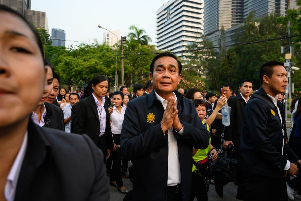 Thailand's Prime Minister Prayut Chan-O-Cha (C) greets people at Lumphini Park in Bangkok on 20 March, 2019.