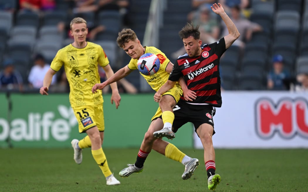 Benjamin Old of the Phoenix and Lachlan Brook of the Wanderers compete for the ball