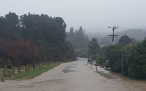 Pōhara Valley Road under water during August flooding.