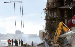Rescuers stand in the smoking ruins of the CTV building in 2011.