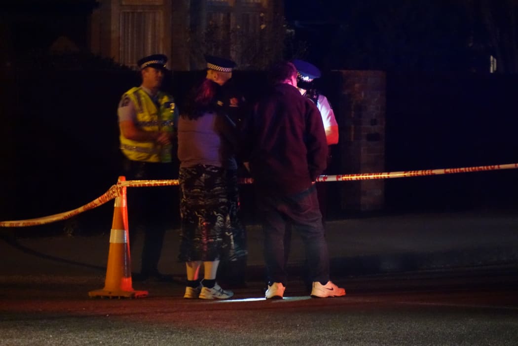 Residents wait to be let past the cordon.