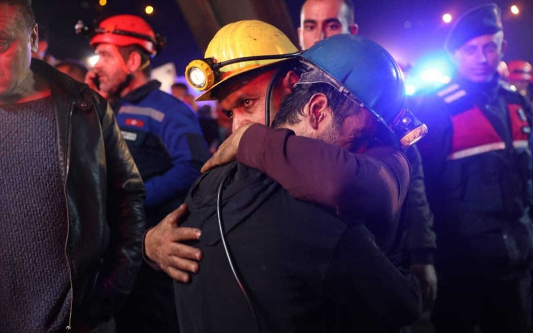 Relatives and friends of the coal miners comfort each other.