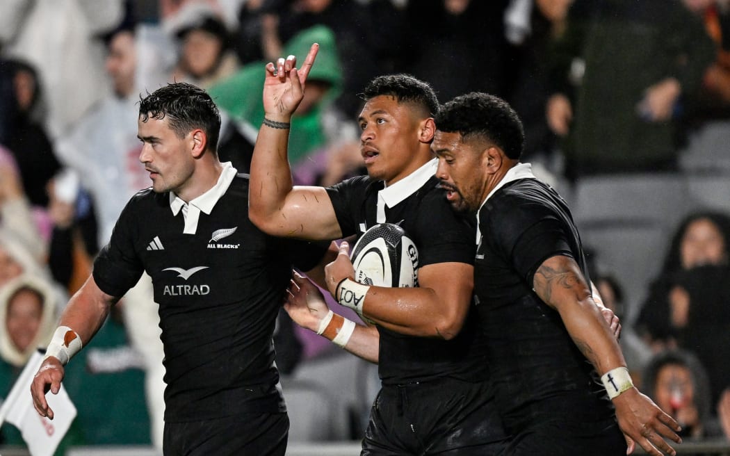 Caleb Clarke of New Zealand celebrates his try with Will Jordan and New Zealand captain Ardie Savea.