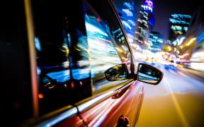 Driving Through City Lights. Car Side and Mirror View. Night Drive Concept