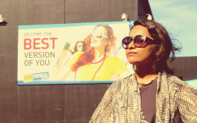 Saziah standing in front of a sign saying "become the best version of you"