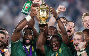 South Africa's Siya Kolisi lifts the Webb Ellis Trophy with Cyril Ramaphosa.