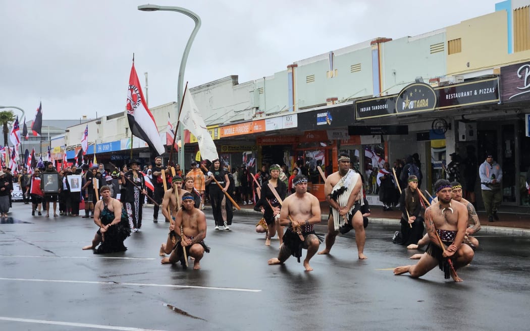 Protestors perform a wero (challenge) while marching through Hastings as part of Hīkoi mō Toitū Te Tiriti.
