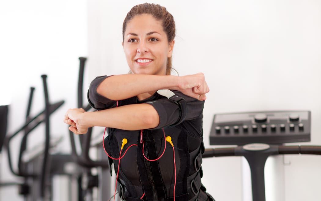 young fit woman exercise on electro muscular stimulation machine