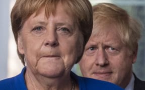 German Chancellor Angela Merkel (L) and British Prime Minister Boris Johnson arrive for a press conference at the Chancellery.