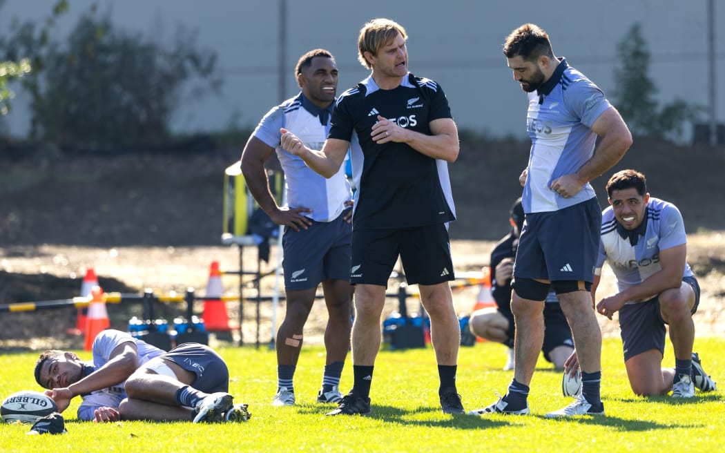 All Blacks head coach Scott Robertson talks with Luke Jacobson at a training session.