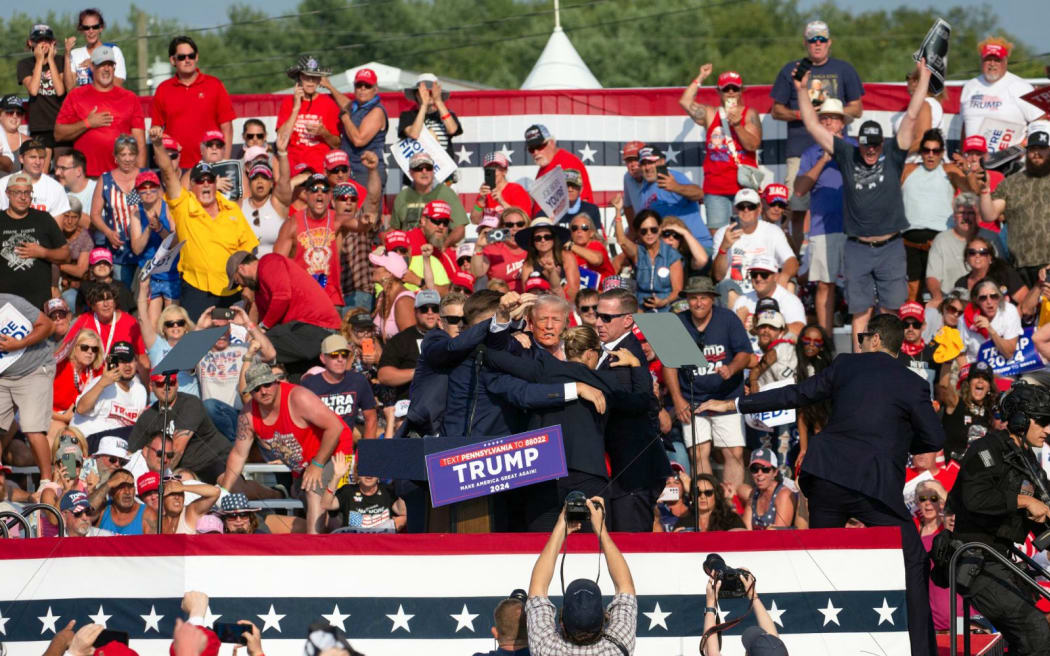 Republican candidate Donald Trump is seen with what appears to be blood on his face surrounded by secret service agents as he is taken off the stage at a campaign event at Butler Farm Show Inc. in Butler, Pennsylvania, July 13, 2024. Republican candidate Donald Trump was evacuated from the stage at today's rally after what sounded like shots rang out at the event in Pennsylvania, according to AFP.
The former US president was seen with blood on his right ear as he was surrounded by security agents, who hustled him off the stage as he pumped his first to the crowd.
Trump was bundled into an SUV and driven away. (Photo by Rebecca DROKE / AFP)