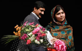 Malala Yousafzai, stands with her father Ziauddin Yousafzai, after addressing the media in Birmingham.
