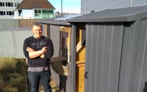 Dr. Damien Scarf, psychology lecturer at Otago University outside his pigeon loft.