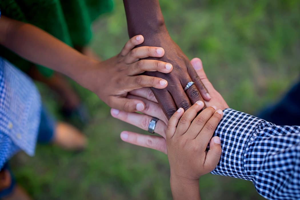 The way we see the world is informed by values inherent in our culture and environment. Different race kids holding hands.