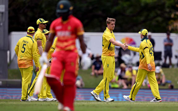 Australia's Cameron Green (2nd R) is congratulated by Steve Smith (R) after dismissing Zimbabwe's Regis Chakabva (C) during the one-day international (ODI) cricket match between Australia (yellow) and Zimbabwe at Riverway Stadium in Townsville on August 28, 2022. (Photo by William WEST / AFP) / -- IMAGE RESTRICTED TO EDITORIAL USE - STRICTLY NO COMMERCIAL USE --