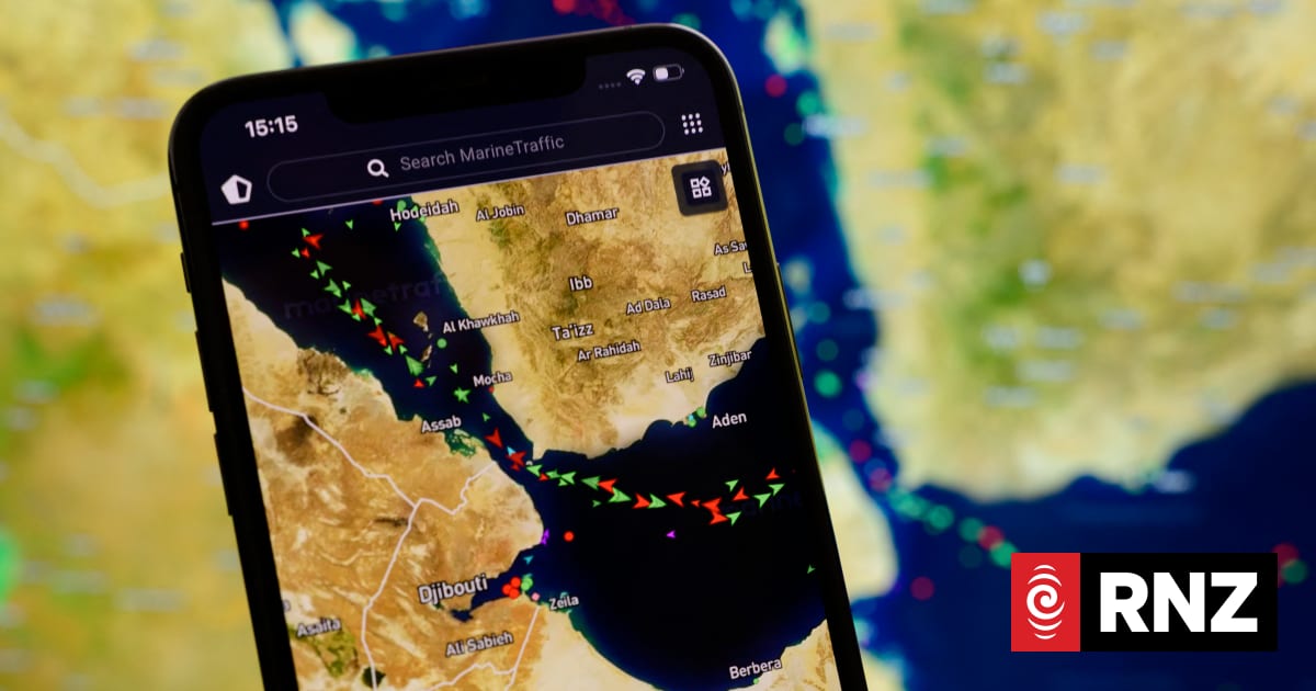 A smartphone screen displays the MarineTraffic map showing a concentration of ship beacons in the Strait of Bab el-Mandeb