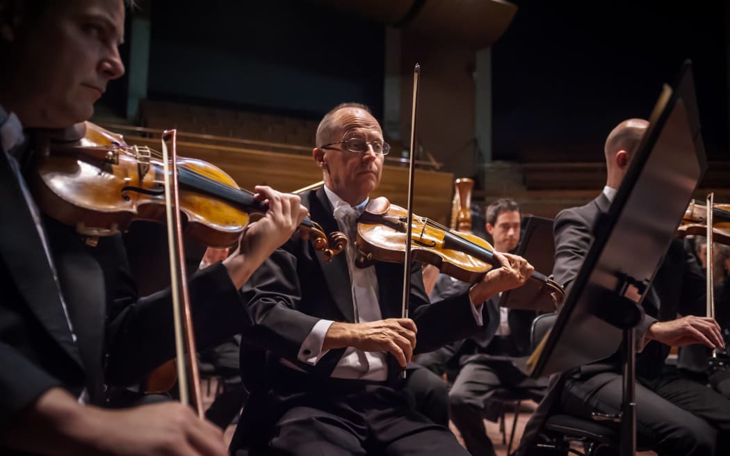 NZSO former Associate Concertmaster Donald Armstrong playing his instrument in the middle of the orchestra.