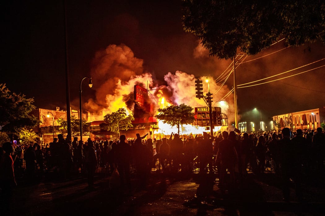 Protesters gather around a liquor store in flames near the also-burned Third Police Precinct in Minneapolis, in a third day of protests after the death of George Floyd.