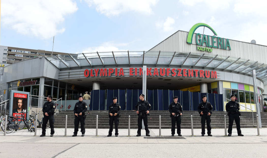 Policemen stand in front of the Olympia-Einkaufszentrum shopping centre in Munich one day after the attack.