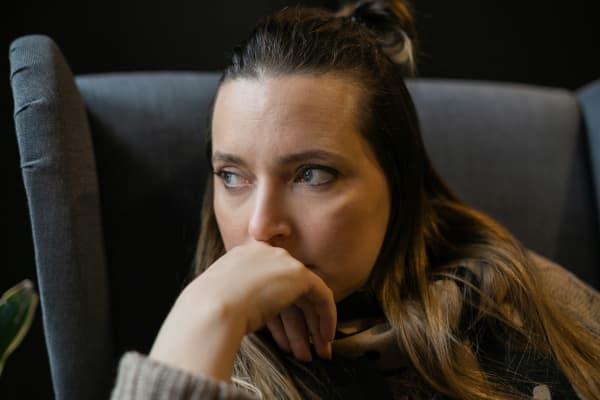 A pensive woman looks to the side.