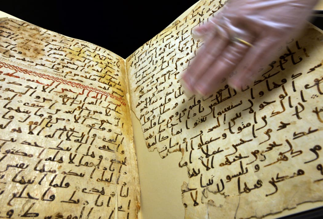 Marie Sviergula, conservator of the University of Birmingham holds a Koran manuscript thought to be at least 1,370 years old.