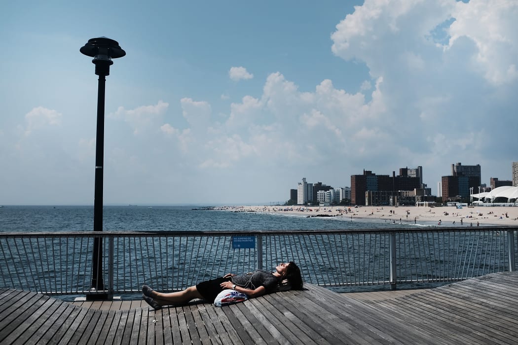 A woman lays along the boardwalk at Coney Island on a hot summer afternoon on August 7, 2018 in New York City.