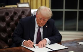 President Donald Trump signs documents as he issues executive orders and pardons for January 6 defendants in the Oval Office at the White House on Inauguration Day in Washington, DC, on January 20.