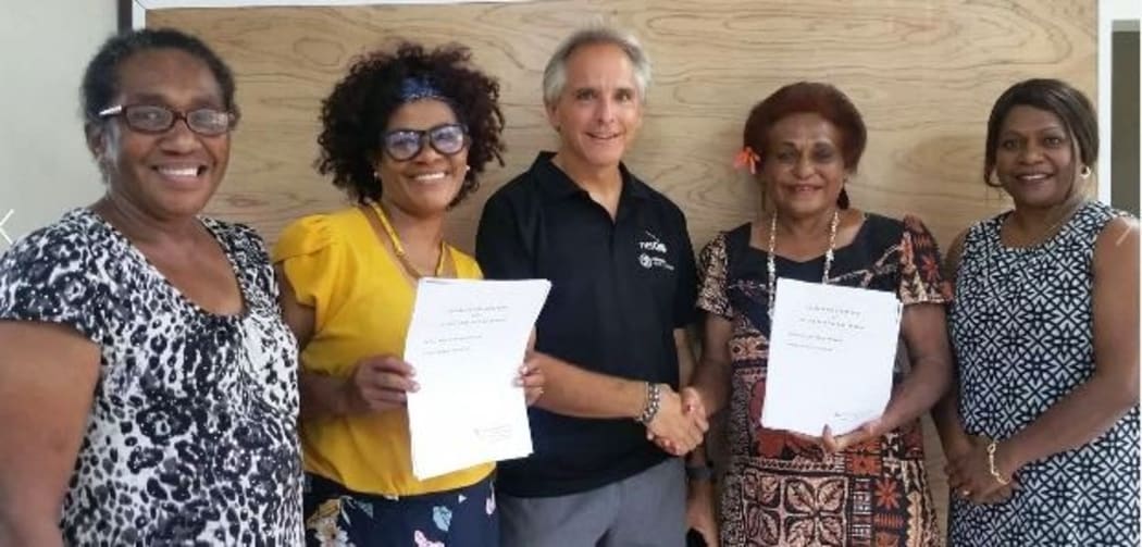 Netball New Zealand's Pacific Sporting Partnership Program Coordinator Ivan Harre (c) and Vanuatu Netball President Kathie Simons (2R) following the signing ceremony.